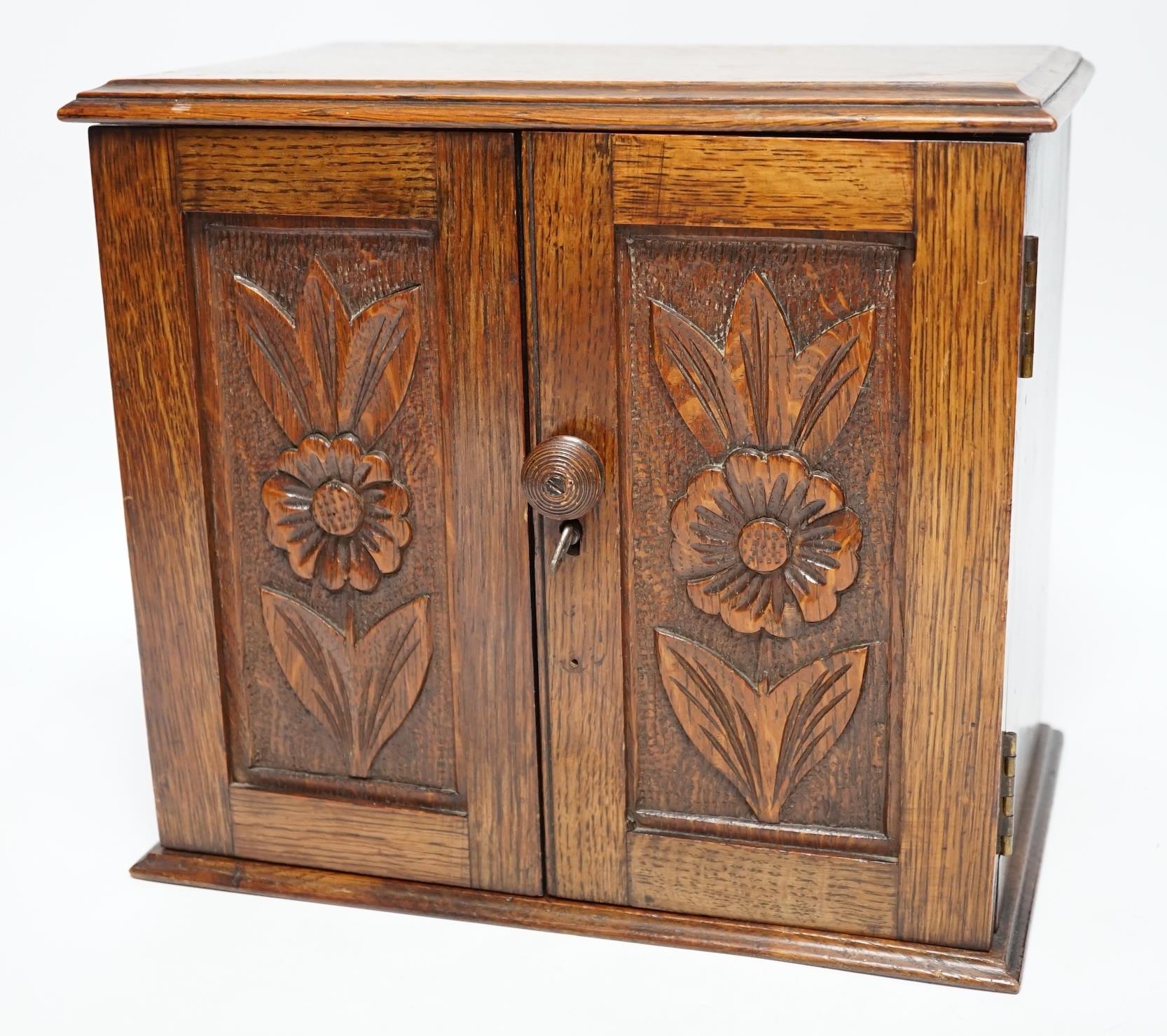 A carved oak smoker's compendium and accessories including cased cheroot holders, 25cm high